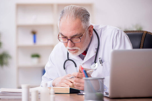 Old doctor working at the hospital