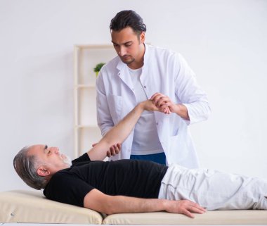 Yaşlı yaralı adam genç doktoru ziyaret ediyor.