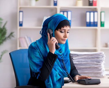 Ofiste çalışan tesettürlü kadın çalışan.