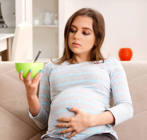 Νεαρή Έγκυος Γυναίκα Που Κάθεται Στον Καναπέ Στο Σπίτι — Φωτογραφία Αρχείου