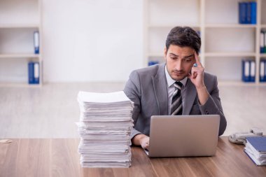 Genç bir çalışan ve ofiste çok fazla iş var.