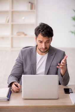 Genç çalışan işyerinde oturuyor.