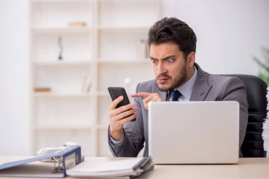 Young employee and too much work at workplace