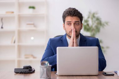 Genç çalışan işyerinde oturuyor.