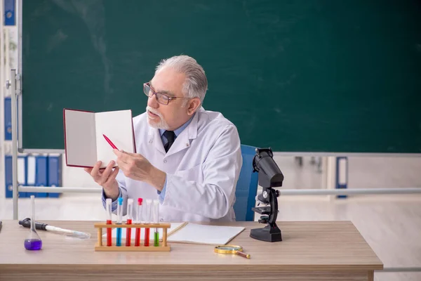 教室に座っている古い化学者の先生 — ストック写真