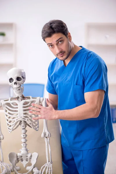 Νεαρός Άνδρας Γιατρός Και Σκελετός Ασθενής Στην Κλινική — Φωτογραφία Αρχείου