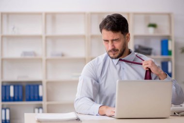 Genç çalışan işyerinde oturuyor.