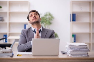 Genç işadamı ve işyerinde çok fazla iş var.