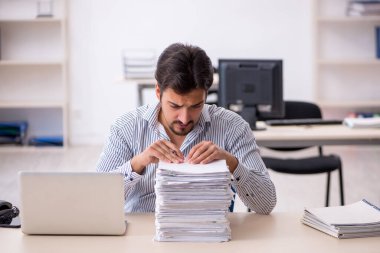 Genç işadamı ve ofiste çok fazla iş var.