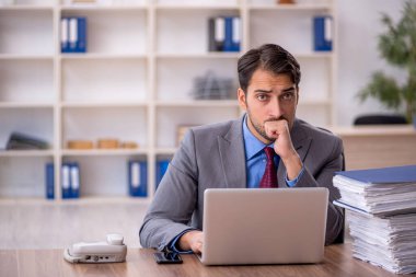 Genç işadamı işyerinde oturuyor.