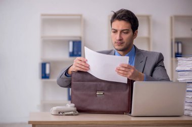 Genç işadamı ve ofiste çok fazla iş var.