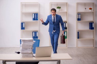 Genç işadamı ve işyerinde çok fazla iş var.