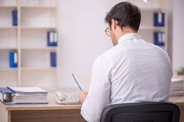 Genç işadamı işyerinde oturuyor.