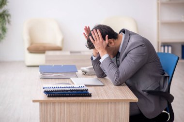 Genç çalışan işyerinde oturuyor.