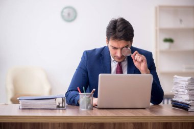 Genç bir çalışan ve ofiste çok fazla iş var.