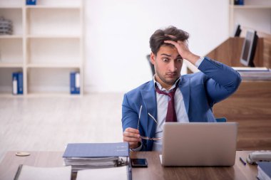 Genç işadamı işyerinde aşırı çalışmaktan memnun değil.