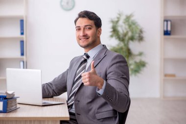 Genç çalışan işyerinde oturuyor.