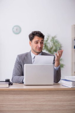 Genç çalışan işyerinde oturuyor.