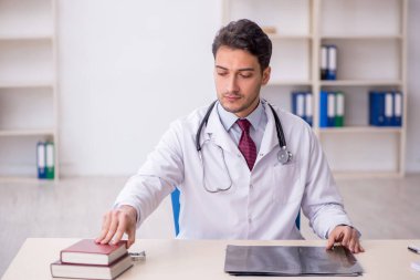 Hastanede kitap okuyan genç bir doktor.