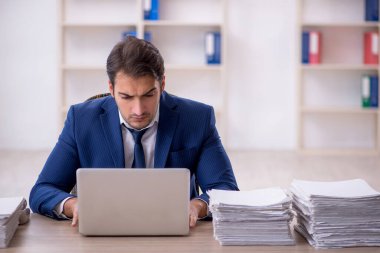 Genç işadamı ve ofiste çok fazla iş var.