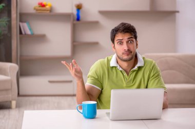 Genç erkek serbest çalışan salgın sırasında evden çalışıyor.