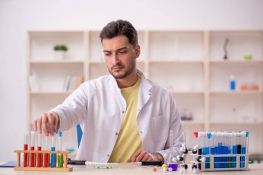 Young chemist sitting at the lab