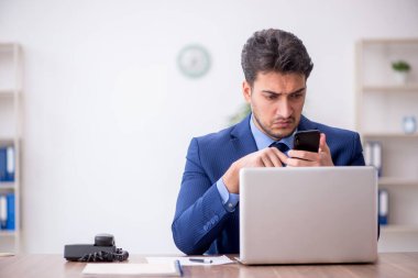Genç bir çalışan ve ofiste çok fazla iş var.