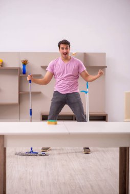 Genç müteahhit evi temizliyor.