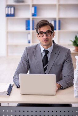 Genç işadamı ve ofiste çok fazla iş var.