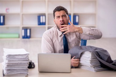 Young employee and too much work at workplace