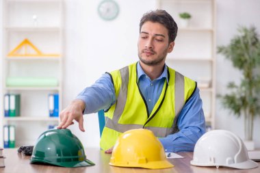 Genç mimar işyerinde oturuyor.