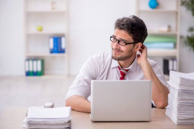 Ofisteki aşırı işten memnun olmayan genç bir çalışan.