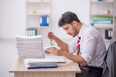 Ofisteki aşırı işten memnun olmayan genç bir çalışan.