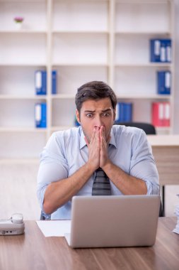 Ofisteki aşırı işten memnun olmayan genç bir çalışan.