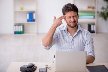 Genç çalışan işyerinde oturuyor.