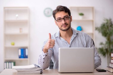 Genç erkek öğrenci işyerinde oturuyor.