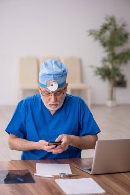 Klinikte çalışan yaşlı doktor otolog.