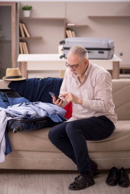 Aged man preparing for trip at home