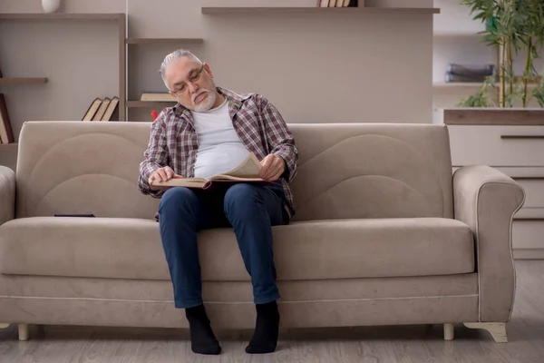 Old man reading book at home during pandemic