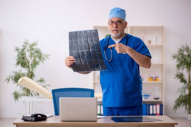 Klinikte çalışan yaşlı bir radyolog.