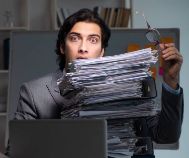 Ofiste geç saatlere kadar çalışan genç erkek çalışan.