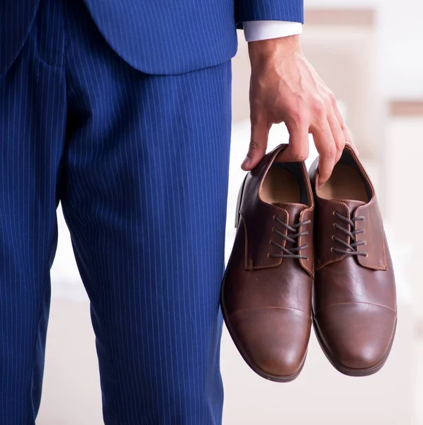 若いハンサムなビジネスマンが家で靴を選ぶ — ストック写真