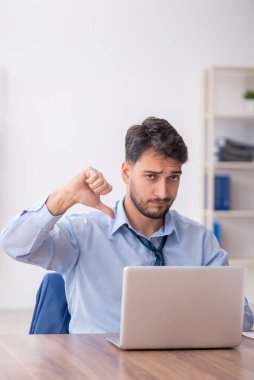 Young employee and too much work at workplace