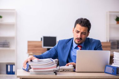 Genç işadamı işyerinde aşırı çalışmaktan memnun değil.