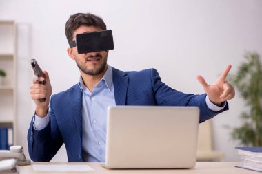 Genç çalışanın iş yerinde sanal gözlüklerle eğlenmesi