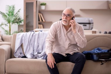 Aged man preparing for trip at home