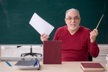 Old teacher sitting in the classroom