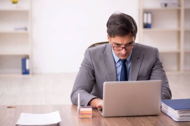 Genç işadamı işyerinde oturuyor.