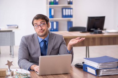 Genç işadamı işyerinde oturuyor.