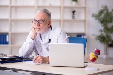 Klinikte çalışan yaşlı bir kardiyolog.